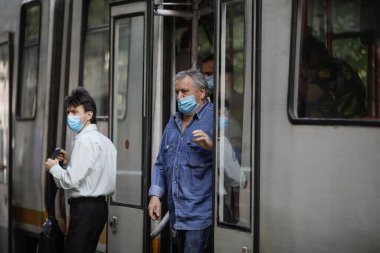 Bükreş / Romanya - 14 Temmuz 2020: Covid-19 salgını sırasında maske takan insanlarla Bükreş 'te tramvay.
