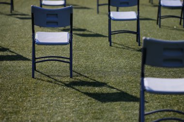 Covid-19 salgını sırasında stadyumun bahçesindeki bir etkinlikte sosyal mesafeyi korumak için sandalyeleri birbirinden ayırıyor..