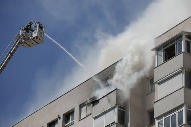 Bükreş, Romanya - 6 Ağustos 2020: İtfaiyeciler bir apartman bloğundaki yangını söndürmeye çalışıyorlar.
