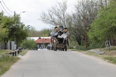Bükreş, Romanya - 1 Mayıs 2020: Roman halkının arabaları metal çöplerle dolu (daha sonra sattıkları) kırsal bir yolda.