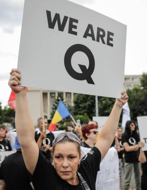 Bucharest, Romania - August 10, 2020: People display Qanon messages on cardboards during a political rally. clipart