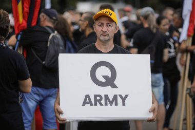 Bükreş, Romanya - 10 Ağustos 2020: Siyasi miting sırasında insanlar Qanon mesajlarını mukavvalarda sergiliyorlar.