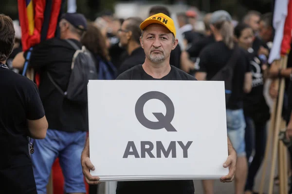 Bükreş, Romanya - 10 Ağustos 2020: Siyasi miting sırasında insanlar Qanon mesajlarını mukavvalarda sergiliyorlar.
