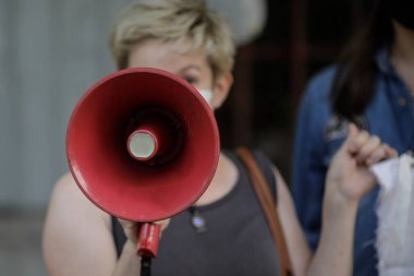 Politik / sosyal konular mitinginde bir kadının elinde tuttuğu megafonla ilgili detaylar.