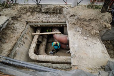 Bükreş, Romanya - 1 Ekim 2020: Bükreş 'in termik enerji dağıtımcısı RADET' in (Termoenergetica) sıcak su borularını değiştirmek için belediye çalışanları tarafından yapılan toprakta delik).
