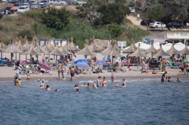 Köstence, Romanya - 5 Temmuz 2020: Covid-19 salgını sırasında insanlar Karadeniz kıyısındaki bir plajda güneşli yaz günlerinde su ve kumun keyfini çıkarıyorlar.