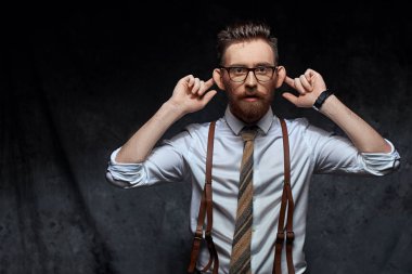 Genç şık hipster işadamı veya Yöneticisi kulakları germe, maymun komik bir şekilde taklit veya kişiyi konuşma işitme ya da diğer sesleri gibi davranarak