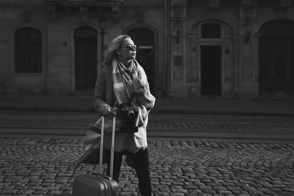 若い美しいブロンドの女性の観光客は、Rynok に立って、動かされる旅行バッグとヴィンテージフィルムカメラで、リヴィウ、ウクライナ — ストック写真