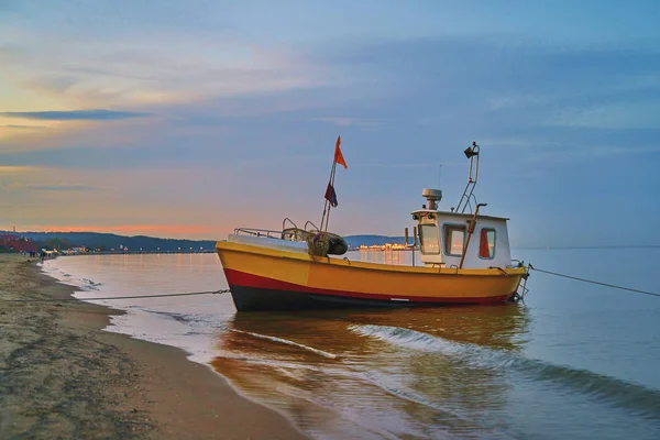 Paysage pittoresque d'un coucher de soleil avec un bateau de pêche sur la plage à Sopot, Pologne . — Photo