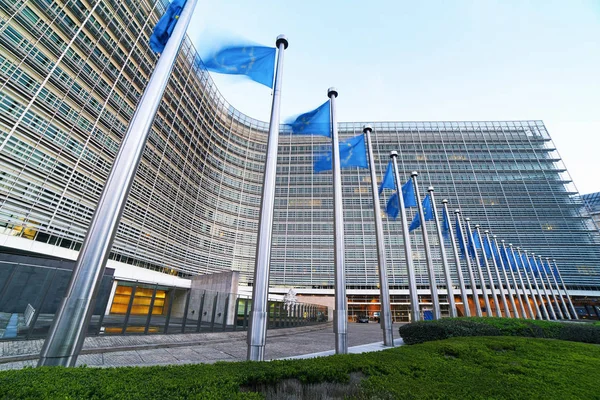 A Berlaymont épület előtt hullámzó európai uniós EU-zászlók, az Európai Bizottság brüsszeli központja. — Stock Fotó
