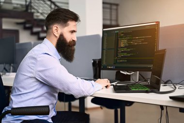 Yazılım programlama. Sakallı adam It ofisinde bilgisayar üzerinde çalışan, masa başı kod yazma, yazılım geliştirme şirketi veya başlangıç bir proje üzerinde çalışıyor. Yüksek kaliteli görüntü.