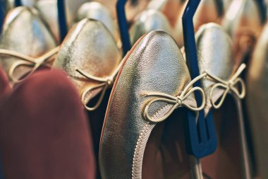 Bir perakende mağazasında askıları üzerinde yay düğümleri ile Altın mahkeme ayakkabı