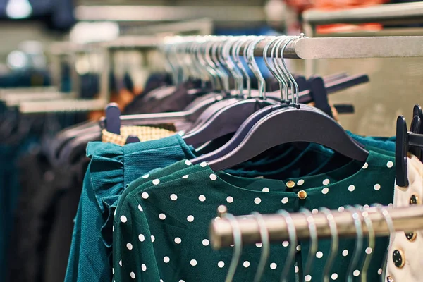 Concetto di tendenza moda. Interno di negozio di vestiti con camicette a pois verdi . — Foto Stock