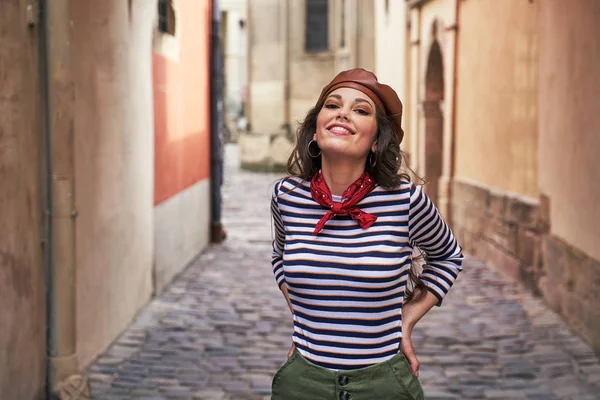 Mladá krásná brunetka oblečená v retro stylu ve starém evropském městě na úzké ulici — Stock fotografie