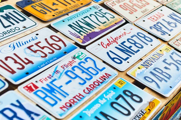 Old discontinued car license plates or vehicle registration numbers from different USA states such as California, Illinois, Nevada, Texas, Arizona. — Stock Photo, Image