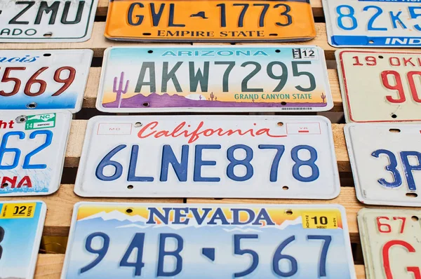 Old discontinued car license plates or vehicle registration numbers from different USA states such as California, Nevada, Arizona. — Stock Photo, Image