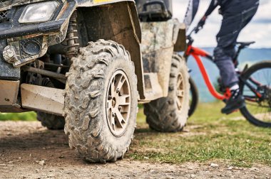 Quadricycle veya dört bisiklet ve bulutlu bir günde dağların arka plan üzerinde bir bisikletçi