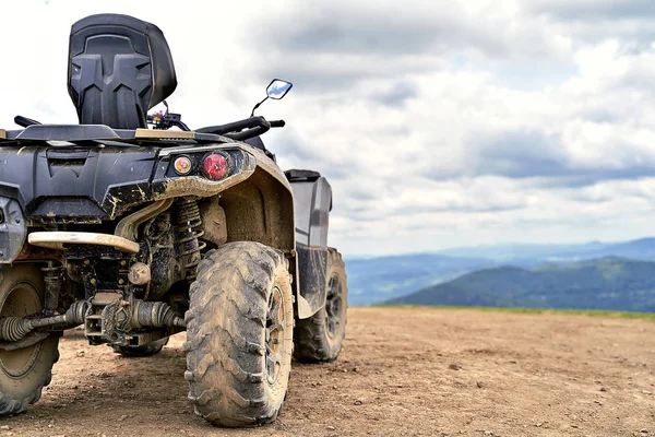 Quadriciclo ou quad bike no fundo das montanhas em um dia nublado — Fotografia de Stock