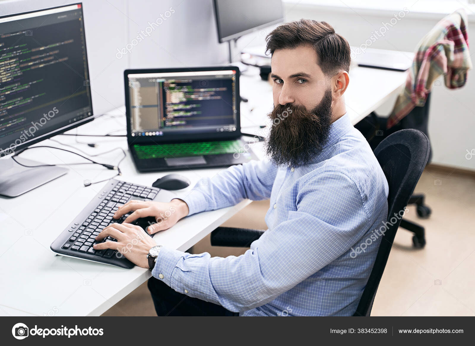 Serious computer programmer developer working in IT office, sitting at desk and coding, working on a project in software development company or startup. High quality image. Stock Photo by ©oleksandrberezko 383452398