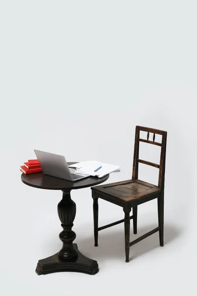 Mesa y silla vacías con libros de ordenador portátil y notas en papel. Aprendizaje a distancia o trabajo remoto desde casa. Aislado sobre fondo blanco. — Foto de Stock