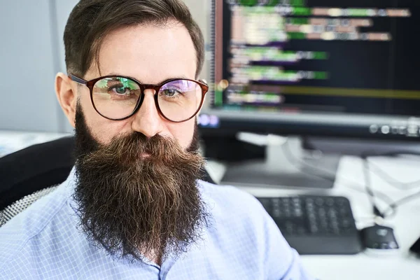 Close-up portret van een serieuze computer programmeur ontwikkelaar werken in IT-kantoor, zitten aan het bureau en coderen van een project in software development bedrijf of startup. Hoge kwaliteit imago. — Stockfoto