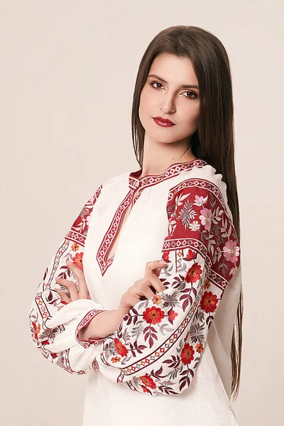 Young beautiful brunette girl wearing gorgeous ethnic style embroidered shirt, modern derivative from traditional Ukrainian vyshyvanka design. Fashion model in studio. — Stock Photo, Image