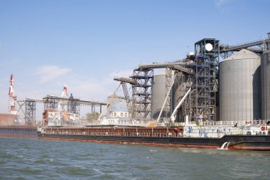 Limandaki bir gemiye tahıl yüklüyor. Nehirden liman altyapısına, tahıl depolama terminallerine görünüm