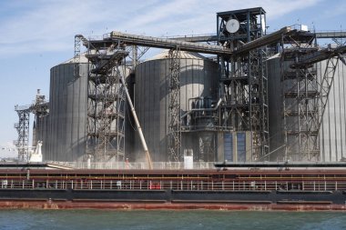 Limandaki bir gemiye tahıl yüklüyor. Nehirden liman altyapısına, tahıl depolama terminallerine görünüm