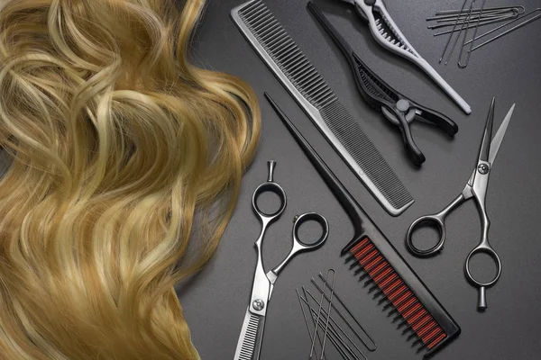 Koyu bir arka plan üzerinde kuaförlük seti ve vurgulanmış saç.