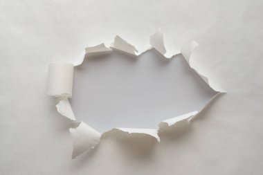 Yanları yırtılmış eski kağıtbir delik.