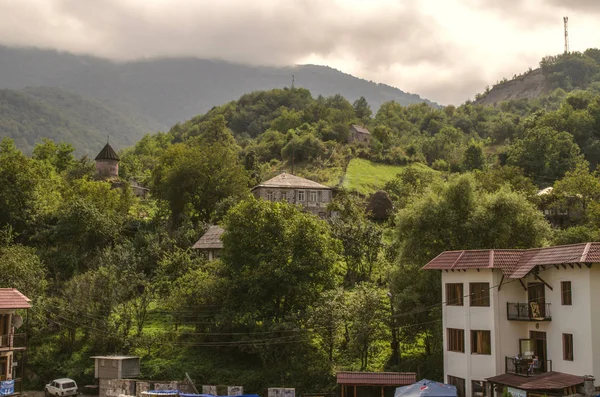 Kapel van St. Sarkis in een bergdorp Gosh met een donkere lucht uit de dikke mist, gelegen in het bos, in de buurt van de stad van huizen — Stockfoto