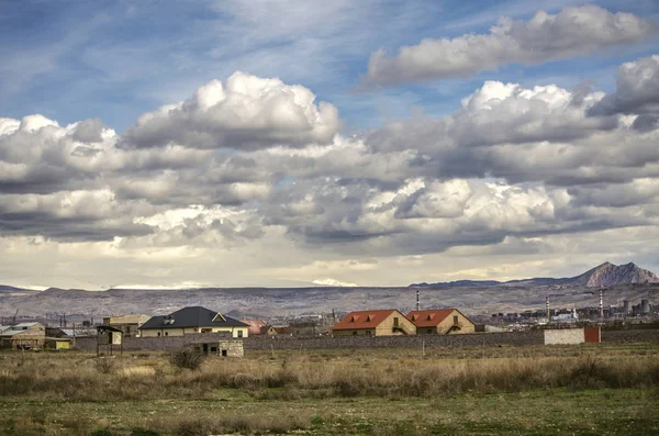 初春在亚美尼亚首都埃里温，内尔金查尔巴赫郊区，有住宅，山景和天空覆盖着雨云 — 图库照片