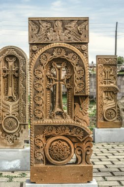 Stone cross carved with ornaments in the form of the second letter  of the Armenian alphabet, created by Mesrop Mashtots in the village of Oshakan clipart