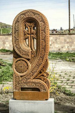 Stone cross carved with ornaments in the form of the sixth letter of the Armenian alphabet, created by Mesrop Mashtots in the village of Oshakan clipart