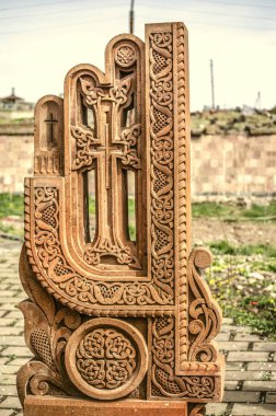 Stone cross carved with ornaments in the form of the thirtieth  letter  of the Armenian alphabet, created by Mesrop Mashtots in the village of Oshakan clipart