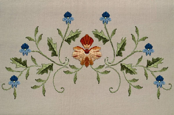 Μοτίβο με κόκκινο-κίτρινο λουλούδι και μπλε λουλούδια σε στριμμένα κοτσάνια με φύλλα για κέντημα σε βαμβακερό ύφασμα — Φωτογραφία Αρχείου