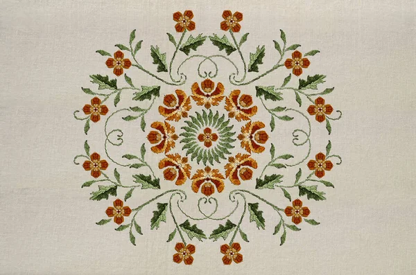 Výšivky kruhového ozdobu oranžových květů na zkroucených stonkách s listy z bavlněné tkaniny — Stock fotografie
