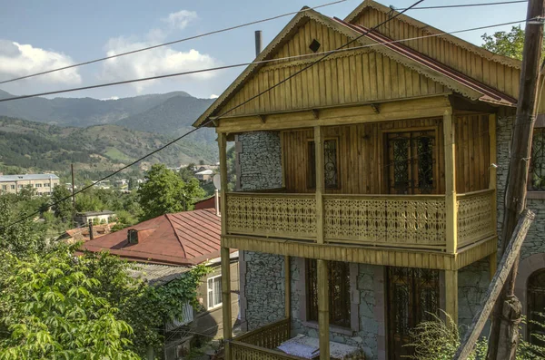 Pemandangan di kota resor tua Dilijan dengan balkon kayu dan kisi-kisi besi tempa di antara pegunungan, ditutupi dengan hutan — Stok Foto