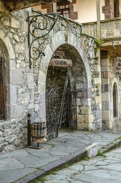 Eingang zur Bäckerei mit schönem Steinbogen und schmiedeeisernem Tor, auf der Straße der alten Kurstadt im alten Dilijan — Stockfoto