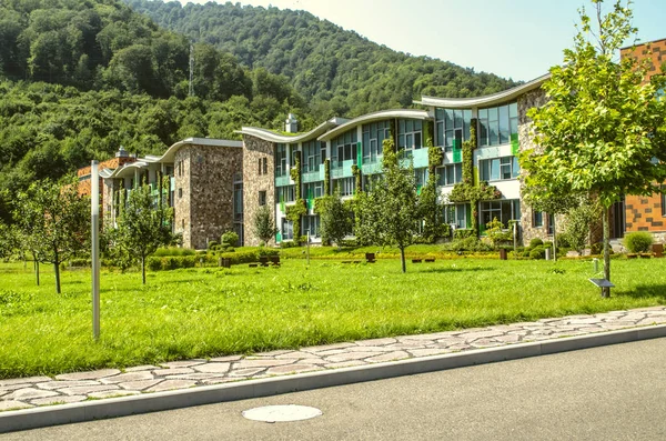 Uitzicht vanaf de weg naar de academische gebouwen aan de International College in Dilijan, omgeven door bos — Stockfoto