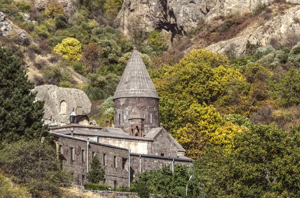 Complejo entero del monasterio de la cueva Geghard en el barranco de la cresta de Geghama contra el fondo de árboles amarillentos del otoño en Armenia — Foto de Stock