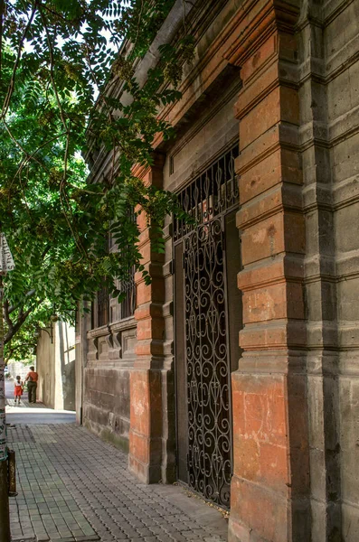 2019年8月27日 亚美尼亚埃里温 位于埃里温Khorenatsi街的一座黑色旧建筑 入口上方有雕刻的墙角和红色窗台 窗户上有锻铁栅栏 — 图库照片