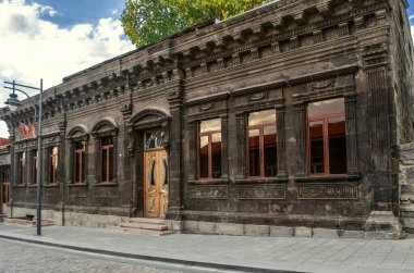 The old one-story building of the 19th century from black tufa in the classical style on Abovyan street in the city of Gyumri clipart