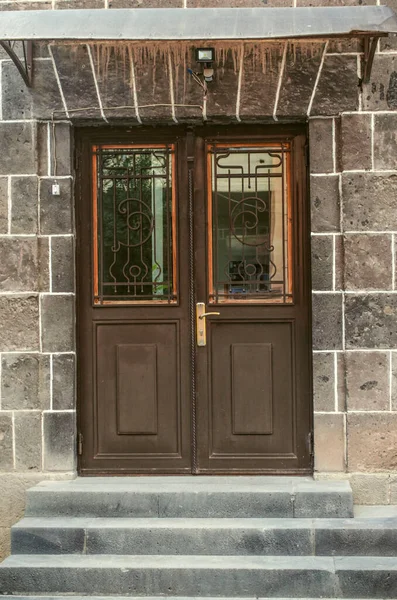 一扇褐色铁制双门 门窗上有华丽的锻铁栏杆 门廊下有楼梯 — 图库照片