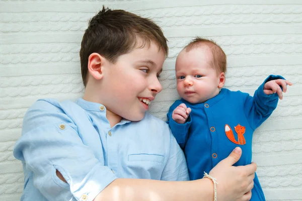 Big brother knuffelen zijn pasgeboren babymeisje. Peuter jongen vergadering nieuwe broer/zus — Stockfoto