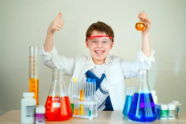 Cute boy is making science experiments in a laboratory — Stock Photo, Image