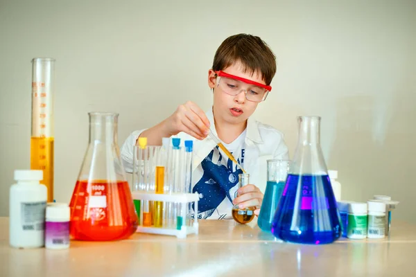 Милый мальчик проводит научные эксперименты в лаборатории — стоковое фото