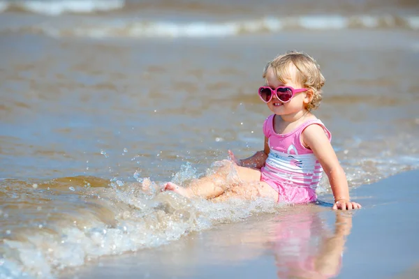 Adorable toddler girl splashing in ocean waves — Stock Photo, Image