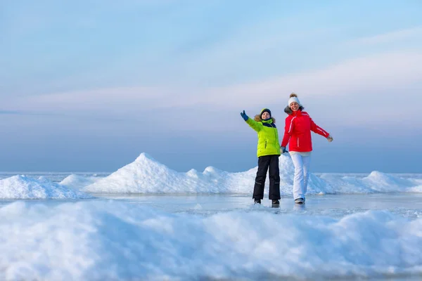 Ung mamma och hennes son på isiga beach — Stockfoto