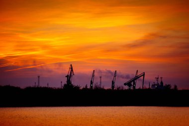 Seaport üzerinde günbatımında vinçler ile görüntüleyin. Akşam kargo Liman Panoraması